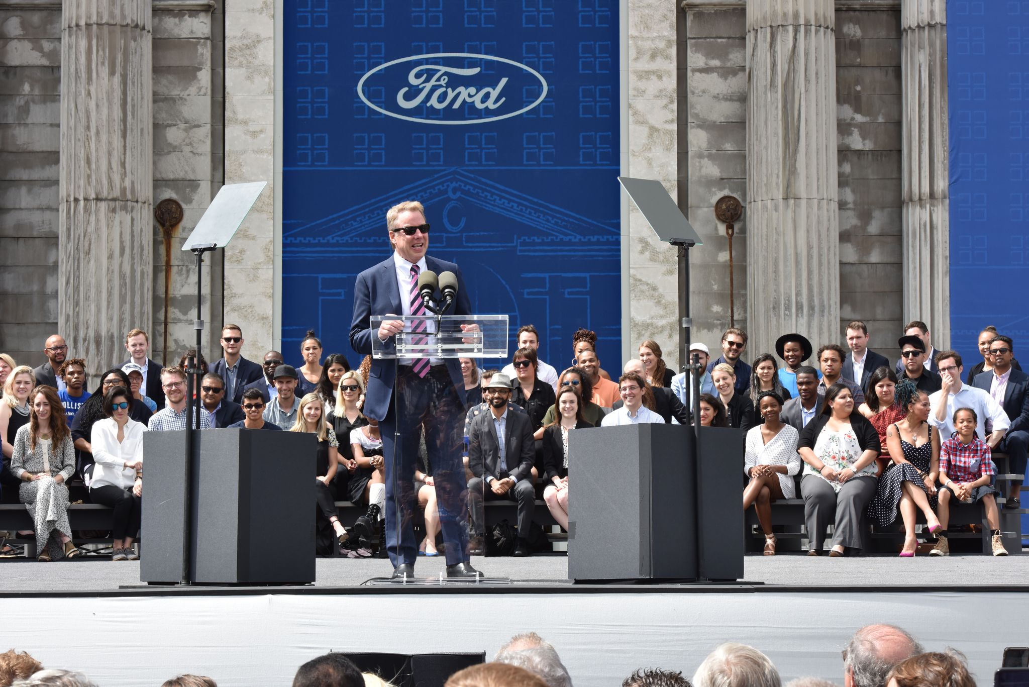 Bill Ford speaking in front of Michigan Central to an audience.