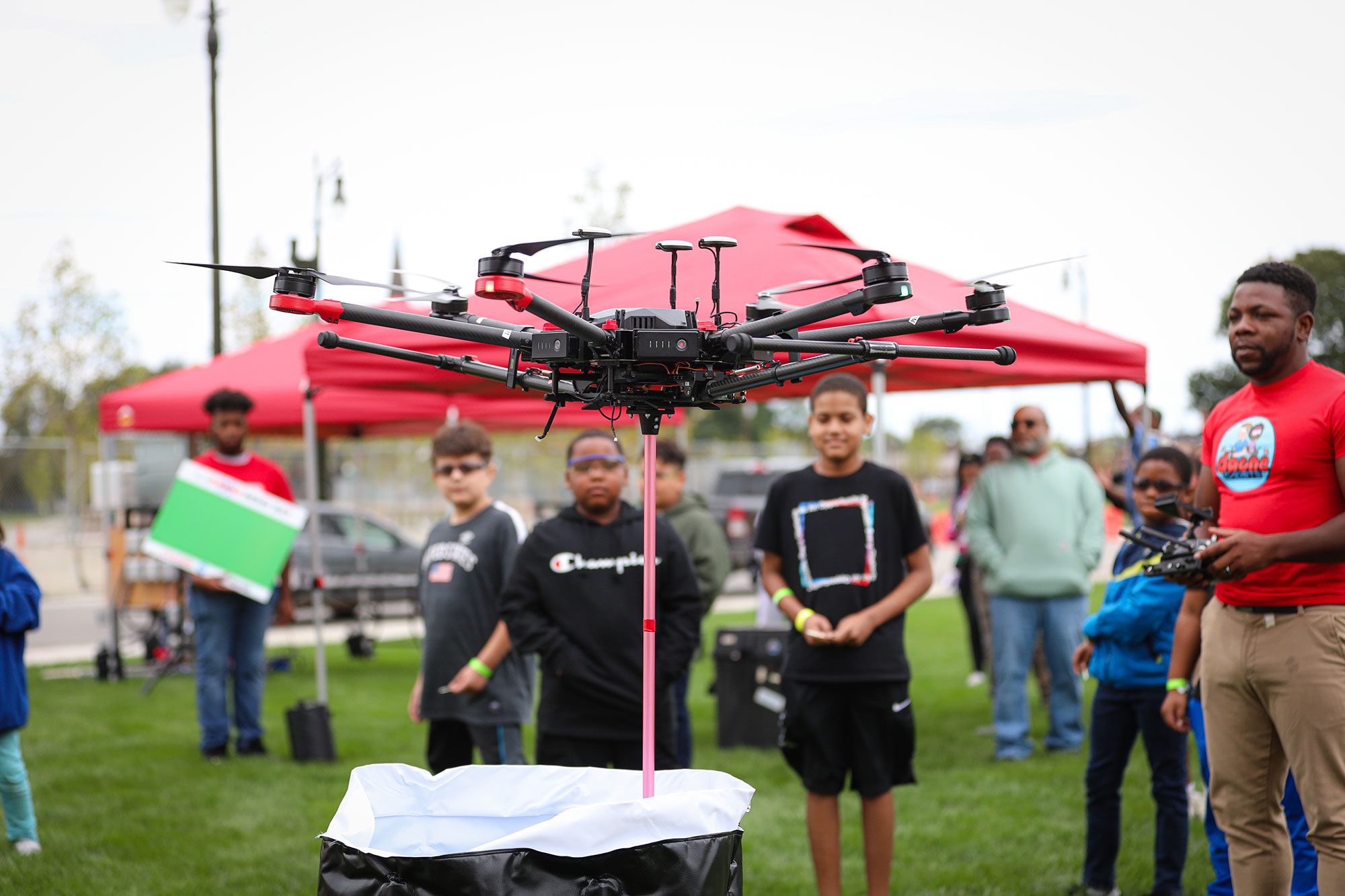 A group of children standby during a Drone operating demonstration.
